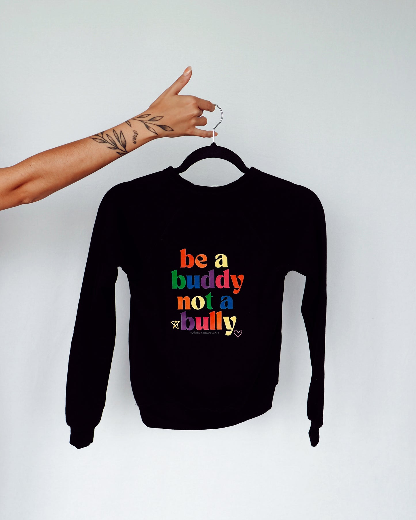 black sweatshirt on a hanger. be a buddy not a bully in rainbow letters. 